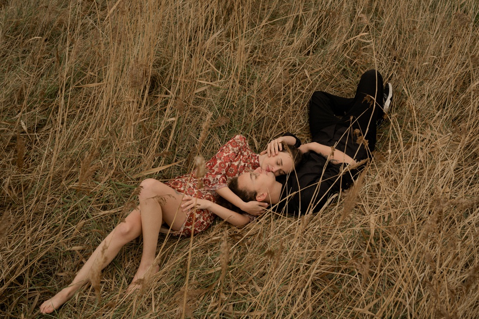 couple allongé dans les herbes hautes, normandie