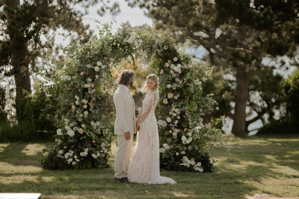 photos de couple devant une arche fleurie